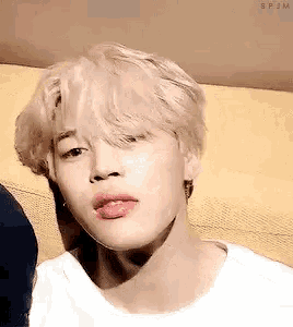 a close up of a person 's face with blonde hair and pink lips .