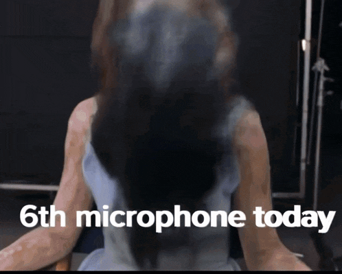 a woman is sitting in front of a 6th microphone today sign