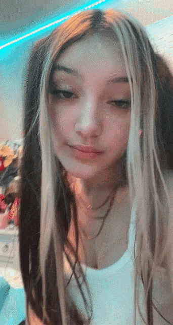 a girl with long hair and a white tank top