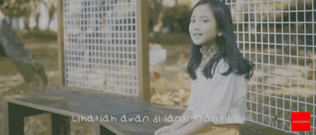 a girl is sitting on a bench with the words " lihatlah awan di langit yang biru " on the bottom