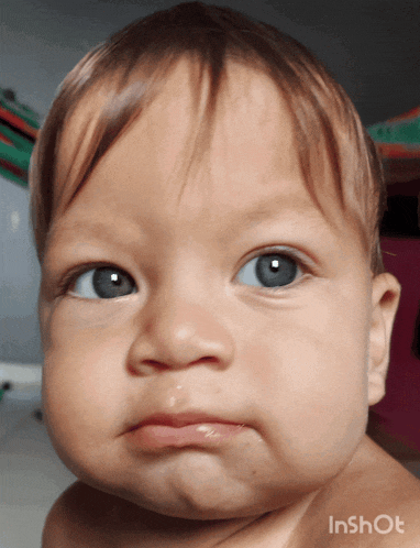 a close up of a baby 's face with the words inshot on the bottom right