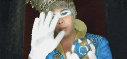 a man in a costume with a crown on his head is holding a crystal ball .