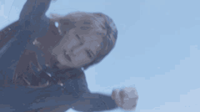 a woman in a superman costume is flying in the air