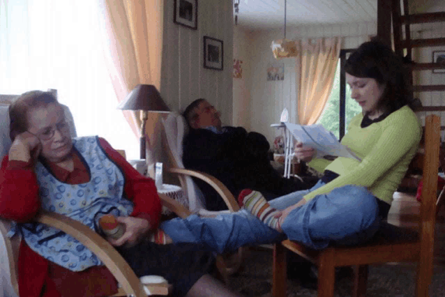 a woman sits in a chair reading a book