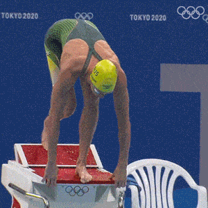 a female swimmer is getting ready to dive into a pool at the tokyo 2020 olympics
