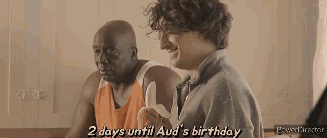 a man eating a banana with the words " 2 days until aud 's birthday " on the bottom
