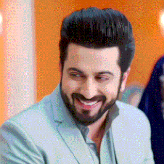a man with a beard is smiling and wearing a suit and shirt .