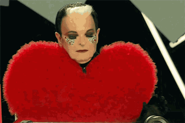 a man wearing a red heart shaped pillow