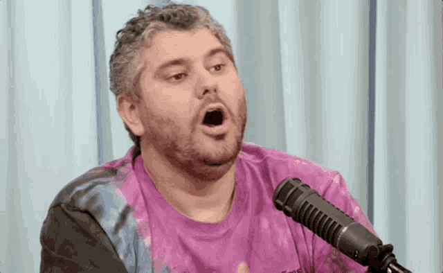 a man with a beard is singing into a microphone .