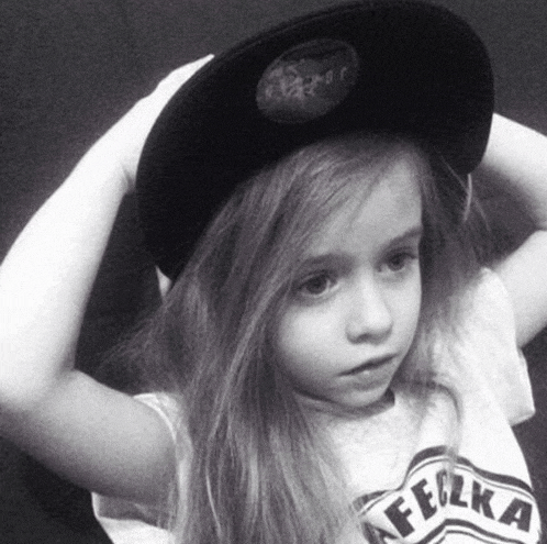 a little girl wearing a hat and a t-shirt with the word felka on it