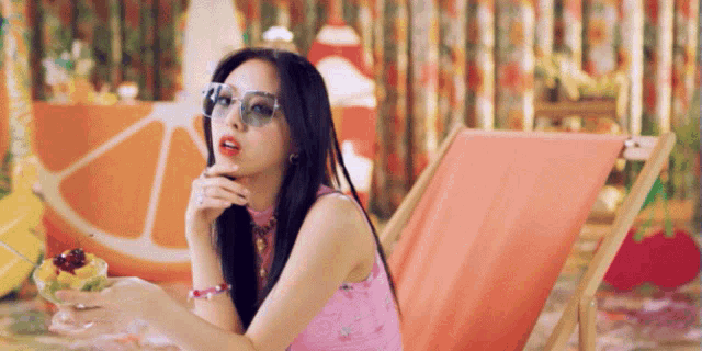 a woman wearing sunglasses is sitting in a chair