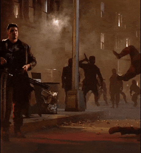 a man in a punisher costume holds a machine gun