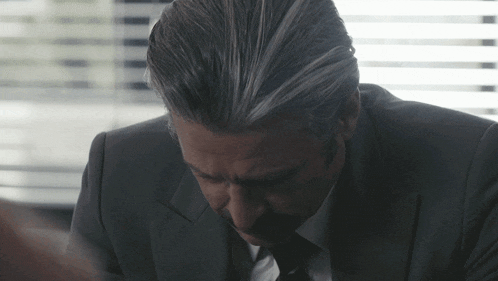 a man in a suit and tie looks down