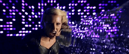 a woman with blonde hair is standing in front of purple lights .
