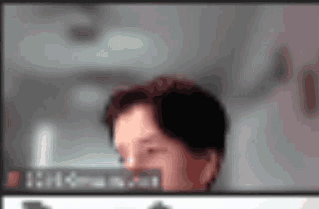 a blurry picture of a man 's face with the numbers 1 : 4 visible