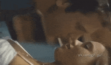 a man and a woman are kissing each other in a bed .