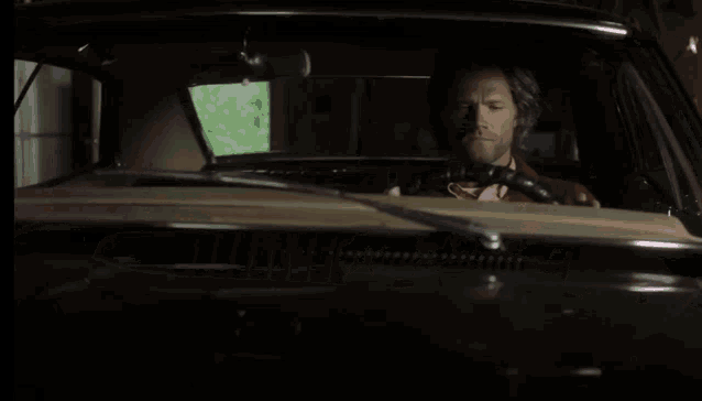 a man in a car with his eyes closed