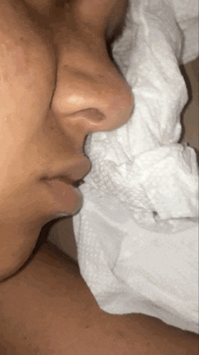 a close up of a person 's nose and mouth with a napkin on it
