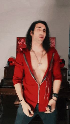 a man with long hair and a red shirt is dancing