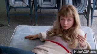 a young woman is laying on a mattress in a room .