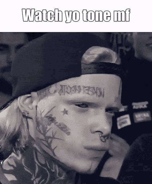 a man with tattoos on his face is wearing a black hat