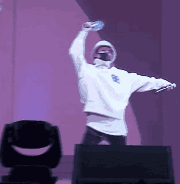 a person wearing a white sweatshirt with the number 999 on it is holding a microphone