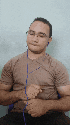 a man wearing glasses and earbuds is making a face