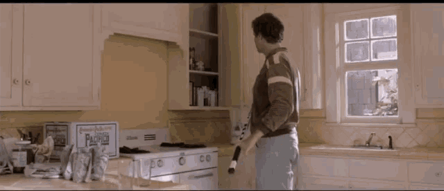 a man standing in a kitchen next to a box that says ' paradise ' on it
