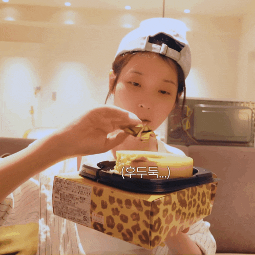 a woman in a white hat is eating a piece of cake