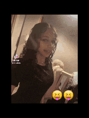 a girl is taking a selfie in front of a mirror with two smiley faces on her face .