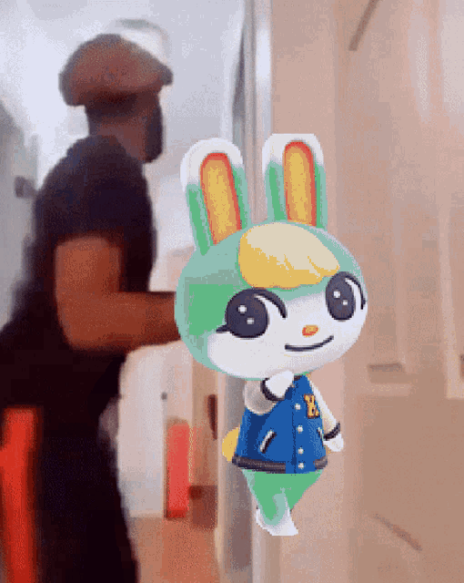 a green and white bunny with the letter b on its jacket