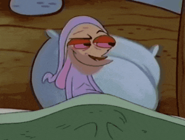 a cartoon character is smiling while laying in bed with a pillow .