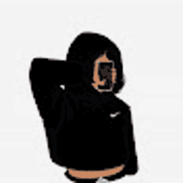 a person wearing a black hoodie is taking a picture of themselves with a cell phone .