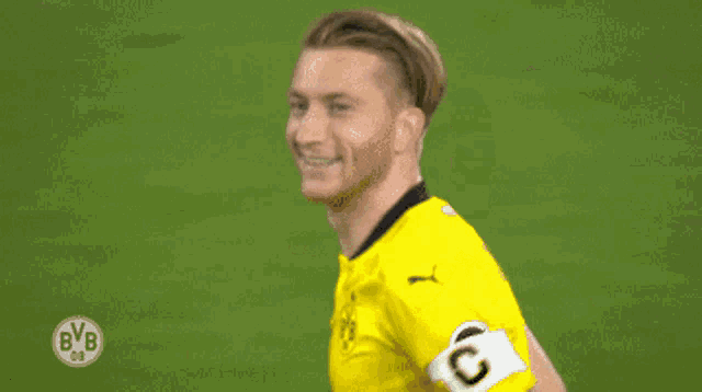 a soccer player wearing a yellow jersey with bvb on the front