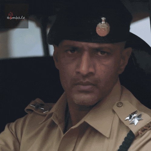 a man in a military uniform is sitting in a car with a label that says hambala