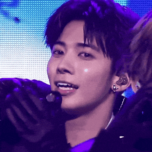 a close up of a person 's face with a microphone in his ear