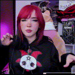a woman with red hair is wearing a black hoodie with a cat on it .