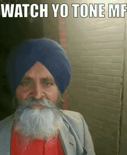 a man with a beard wearing a blue turban says watch yo tone mf