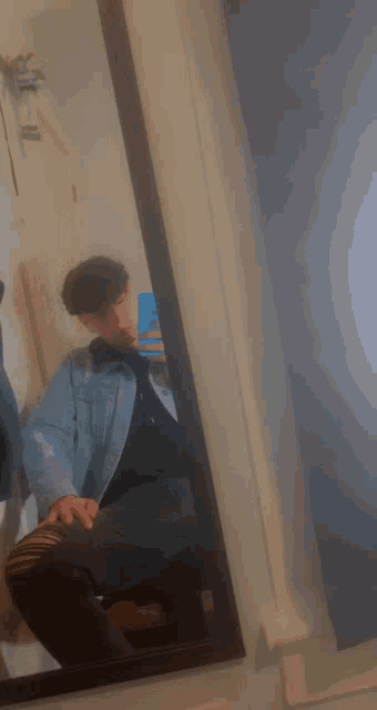 a young man is taking a selfie in front of a mirror