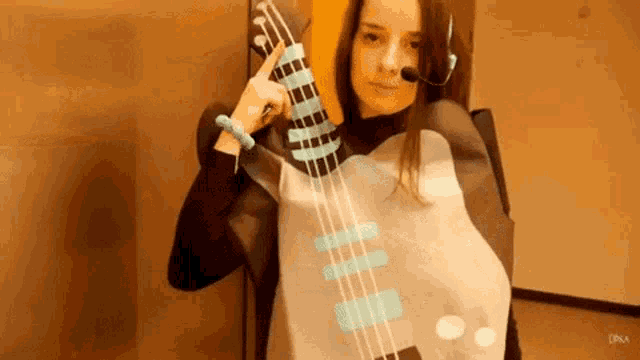 a woman in a guitar costume is holding a guitar in her hand .