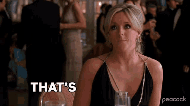 a woman in a black dress is sitting at a table and saying that 's