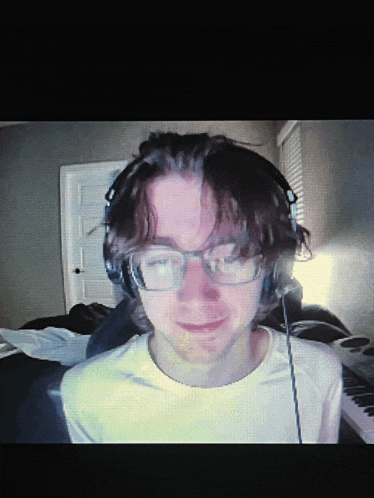 a young man wearing glasses and headphones is looking at the camera