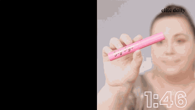 a woman is holding a pink tube of tarte i big ego vegan mascara in her hand