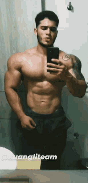 a shirtless man is taking a selfie in front of a mirror with the words @kuangliteam on the bottom