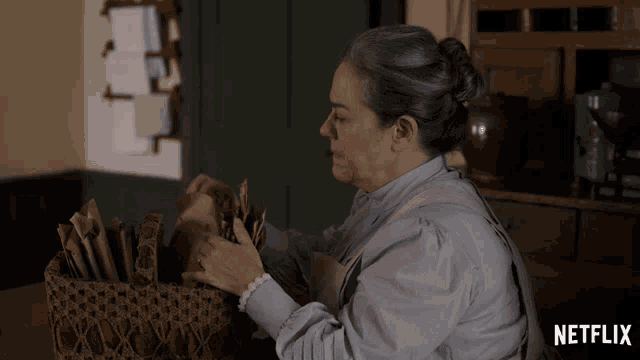 a woman is sitting in front of a basket with netflix written on the bottom