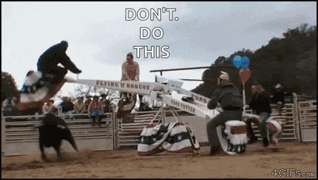 a man is riding a bull on a seesaw in a rodeo while another man rides a cooler .
