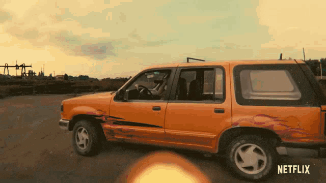 an orange car with flames painted on the side is parked in a netflix advertisement