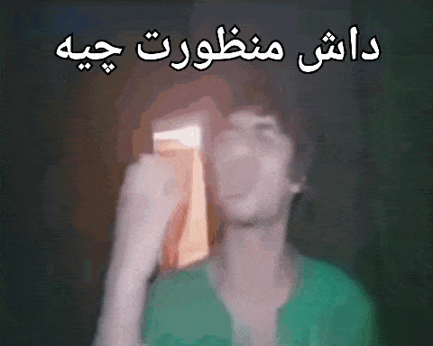a man in a green shirt is holding a piece of paper in front of his face