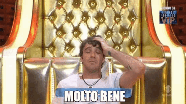 a man is sitting in a chair with molto bene written on a sign