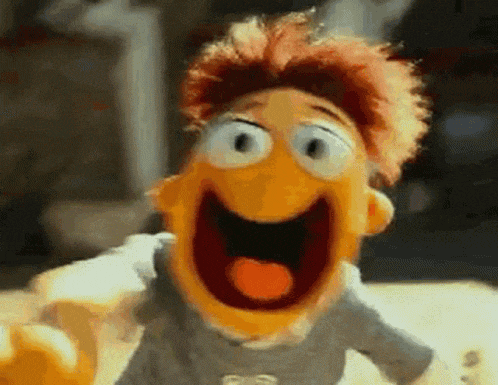 a close up of a puppet with its mouth open and tongue out .